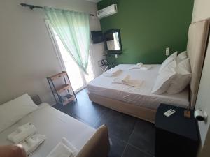 a hotel room with two beds and a window at Pool me up 22 apartment in Megali Ammos