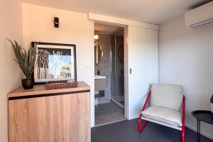 a room with a chair and a mirror and a bathroom at Waterman Beach Village in Supetar