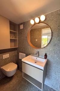 a bathroom with a sink and a toilet and a mirror at Waterman Beach Village in Supetar