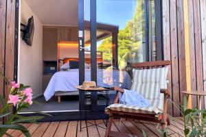 a bedroom with a bed and a chair on a deck at Waterman Beach Village in Supetar