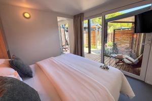 a bedroom with a bed and a balcony with a view at Waterman Beach Village in Supetar