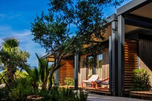a house with a deck with two chairs on it at Waterman Beach Village in Supetar