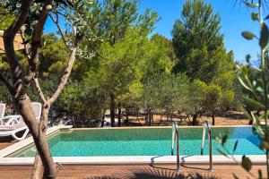 a swimming pool with trees in the background at Waterman Beach Village in Supetar