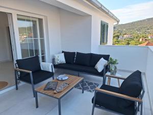 a living room with a couch and chairs and a table at Apartmani Jerka in Vinišće