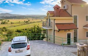 a white car parked in front of a house at Awesome Home In Mirlovic Polje in Mirlović-Polje