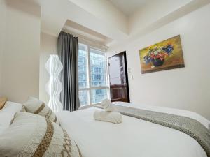 a bedroom with two beds and a window at Modern 1BR w Exclusive Pool Access in Lapu Lapu City