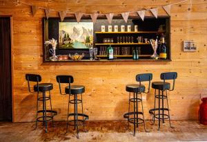 a bar with black stools against a wooden wall at Bendorfer Stadl mit Whirlpool & Sauna in Bendorf