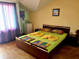 a bedroom with a bed with two pillows on it at Цар Калоян in Primorsko