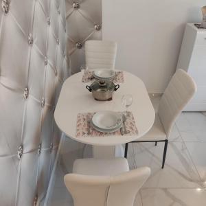 a white table with a tea set on it at Studio apartman Franka in Vukovar