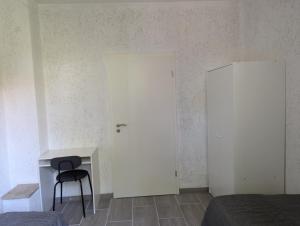 Una habitación con una puerta blanca y un escritorio y una silla. en Ferienwohnung Coppenbrügge, en Coppenbrügge