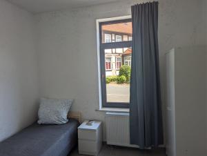 Una pequeña habitación con una cama y una ventana. en Ferienwohnung Coppenbrügge, en Coppenbrügge