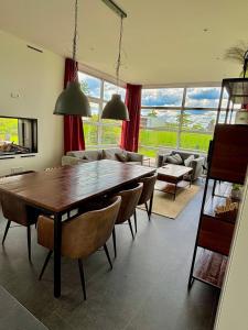 a living room with a large wooden table and chairs at Marina Strandbad Chalet RiverLodge mit Zaun Haus Nr 94 in Olburgen +10 photos