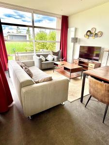 a living room with a couch and a table at Marina Strandbad Chalet RiverLodge mit Zaun Haus Nr 94 in Olburgen