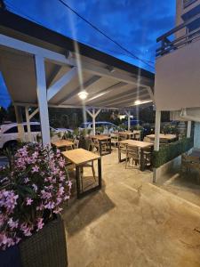 a patio with wooden tables and benches and flowers at Casa Coral Mamaia Nord in Mamaia Nord