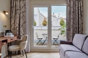 a living room with a couch and a table and chairs at Posy Hotel by Happyculture in Paris