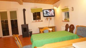 a dining room with a green table and a fireplace at Canal Grande in Stronie Śląskie