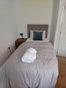 Una cama con una almohada blanca encima. en Diadem Comfort Suites, en Dartford