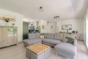 a living room with a couch and a table at Charmante maison 6 à 8 pers PMR proche Lyon in Seyssuel