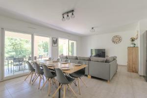 a living room with a table and a couch at Charmante maison 6 à 8 pers PMR proche Lyon in Seyssuel