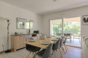 a dining room with a long table and chairs at Charmante maison 6 à 8 pers PMR proche Lyon in Seyssuel +12 photos