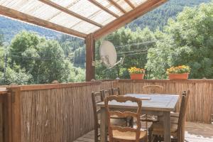 a wooden table and chairs on a deck with a view at La Petite Serenne - Vue Montagne 