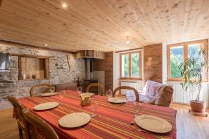 a dining room with a table with plates and wine glasses at La Petite Serenne - Vue Montagne  +7 photos