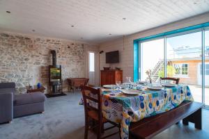 a dining room with a table and a large window at Ty Penn Ar Bed - Proche de la Plage in Plomodiern
