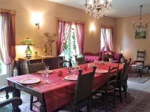 a dining room with a red table and chairs at Les Chambres de la Nied in Condé-Northen