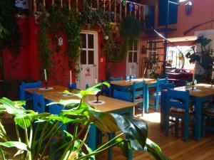 a restaurant with tables and blue chairs and plants at Hotel Churup in Huaraz