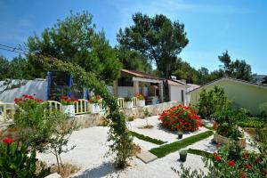 a garden with flowers and a fence at Secluded house with seawater pool in Milna