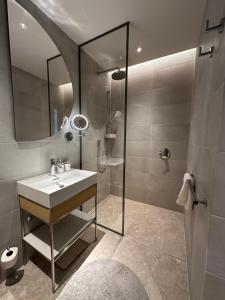 a bathroom with a sink and a shower with a mirror at Boka Place Home Thea in Tivat +16 photos