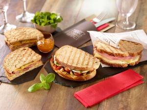 three sandwiches on a plate on a wooden table at ibis Brussels Centre Chatelain in Brussels