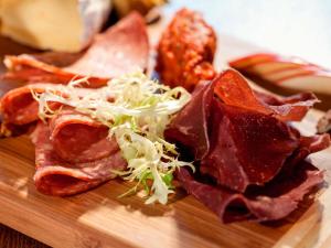 a wooden cutting board with meat and coleslaw on it at ibis Brussels Centre Chatelain in Brussels
