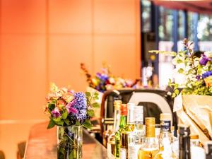 a table with flowers in vases and bottles of wine at ibis Brussels Centre Chatelain in Brussels