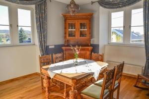 a dining room with a table and chairs and windows at Gästehaus auf der Burg im Vulkan Park Laacher See in Andernach