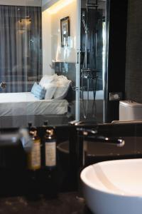 a bathroom with a bed and a sink and a mirror at H Boutique Peña Parda in La Herradura