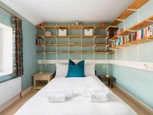 - une petite chambre avec un lit et des étagères dans l'établissement Pass the Keys Traditional 3 Bed Cottage in Historic Village, à Stratford-upon-Avon