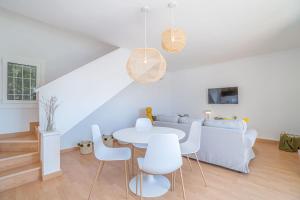 a white living room with a white table and chairs at Milenial Immo Almadrava Roses Beach House in Roses