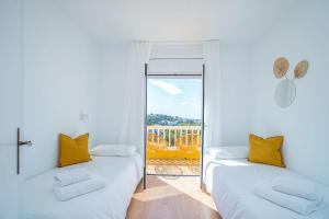 two beds in a room with a balcony at Milenial Immo Almadrava Roses Beach House in Roses