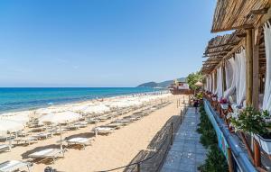 a beach with chairs and umbrellas and the ocean at Beautiful Apartment in Santa Maria di Castellabate