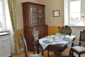 a dining room with a table and a cabinet at Gästehaus auf der Burg im Vulkan Park Laacher See in Andernach +8 photos