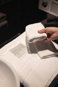 a person holding a pile of white towels on a counter at H Boutique Peña Parda in La Herradura