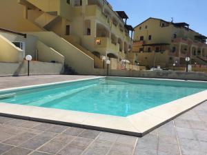 une piscine devant un bâtiment dans l'établissement Castelsardo Romantica, à Castelsardo