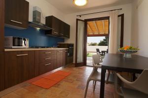 a kitchen with a table and a dining room at BfB Residence San Marco in Sciacca