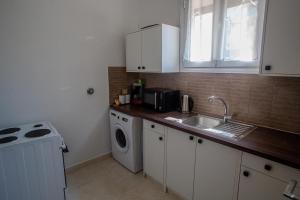 a kitchen with a sink and a washing machine at Aegean Sunset Loft in Rhodes Town