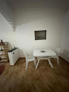 a white table and two white chairs in a room at Diki Beach Cosy place in Hammidane