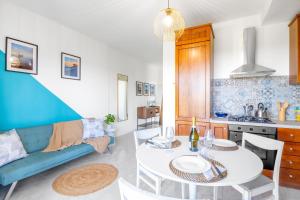 a kitchen and living room with a table and a couch at Neela Apartment Romantic Lake View with Balcony & Parking in Desenzano del Garda