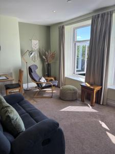 a living room with a blue couch and a window at Bryn Melyn Apartments in Barmouth