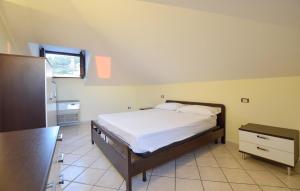 a bedroom with a bed and a dresser and a window at Beautiful Apartment in Santa Maria di Castellabate