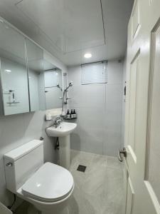 a white bathroom with a toilet and a sink at Hi Seoul Daechi in Seoul